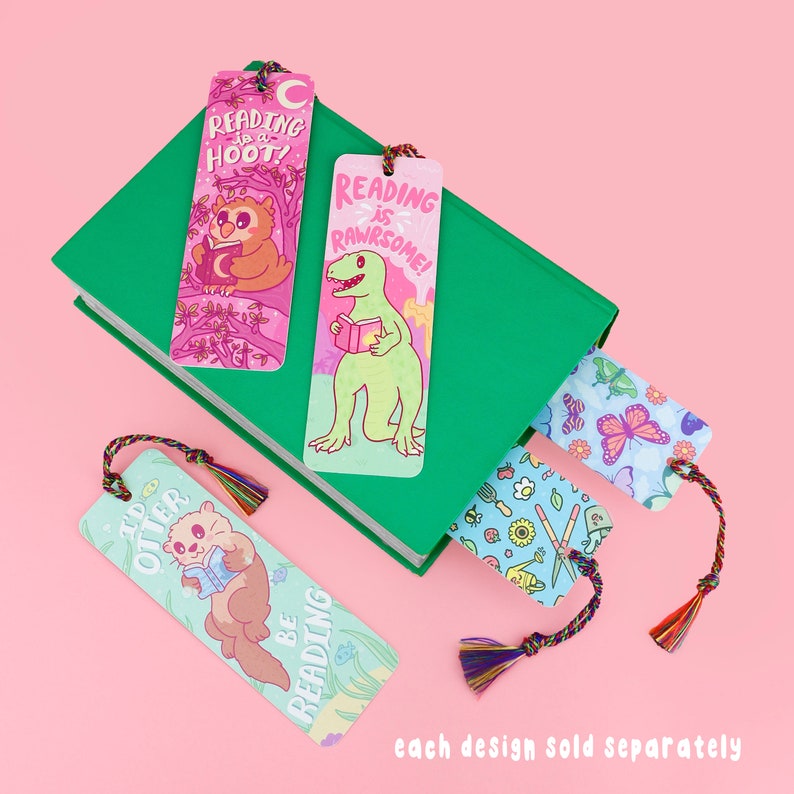 Pu&ograve; includere: Quattro segnalibri colorati con diversi design. I segnalibri presentano illustrazioni di un gufo, un dinosauro, una lontra e una farfalla. I segnalibri hanno il testo "Reading is a Hoot!" "Reading is Rawrsome!" "I'd Otter Be Reading" e "Ogni design venduto separatamente".