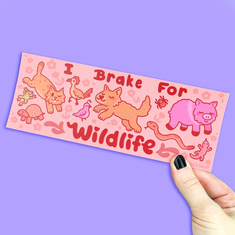 May include: Pink and red sticker with the text "I Brake For Wildlife" and cartoon animals including a wolf, a pig, a snake, a turtle, a bird, a frog, and a cat.