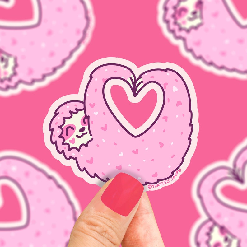 May include: Pink sloth sticker with a heart-shaped outline. The sloth is holding a pink heart in its arms. The sticker has a white outline and the text "TURTLES SOUP" in the bottom right corner.