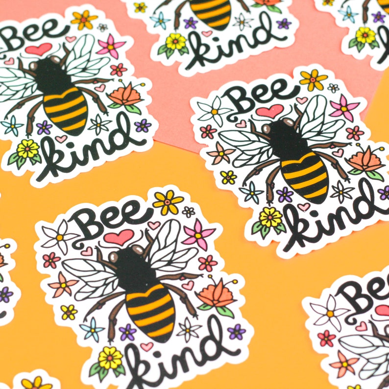 May include: A set of six bee-themed stickers with the text "Bee Kind" in black script. Each sticker features a cartoon bee with black and yellow stripes, surrounded by colorful flowers and hearts.