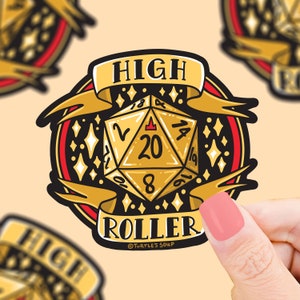 May include: A gold and red sticker with a 20-sided die, stars, and the text "HIGH ROLLER" with a copyright symbol and "TURTLE'S SOUP".