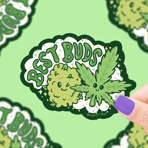 Pode incluir: Um adesivo verde e branco com o texto "Best Buds" em uma fonte de bolhas. Duas folhas de maconha de desenho animado com rostos est&atilde;o sorrindo uma para a outra. O adesivo est&aacute; em um fundo verde.