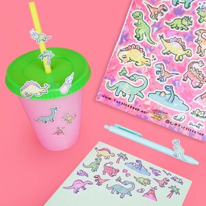 May include: A set of colorful dinosaur stickers on a pink background. The stickers feature various dinosaurs, including a stegosaurus, a triceratops, and a brachiosaurus. The stickers are perfect for adding a fun and whimsical touch to any project.