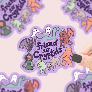 May include: Purple sticker with the text "friend to cryptids" in white. The sticker features illustrations of various cryptids, including a ghost, a bat, a frog, a sasquatch, a monster, and a serpent.
