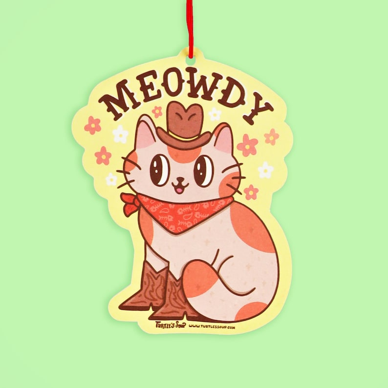 May include: A yellow and orange cat wearing a cowboy hat and bandana with the text "MEOWDY" on a yellow background with white flowers.