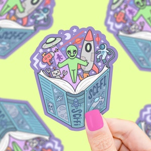 May include: A purple and blue sticker with a book open to reveal a rocket, alien, and other space-themed illustrations. The book cover reads "Sci-Fi".