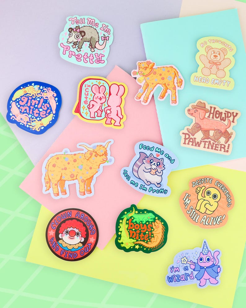 Puede incluir: Una colecci&oacute;n de pegatinas coloridas con varios personajes de dibujos animados y frases. Los dise&ntilde;os incluyen una zarig&uuml;eya, conejitos, un perro, un gato, un payaso y un gato mago. Frases: "Tell me I'm Pretty", "Girl's Nite" y "I'm Still Alive!"