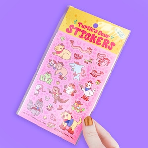 May include: A pink sheet of stickers featuring various cartoon animals wearing cowboy hats and holding items like a lasso, a gun, and a horseshoe. The stickers are from Turtle's Soup and feature the text "Turtle's Soup Stickers".