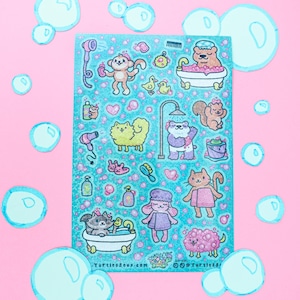 May include: A sheet of stickers with a teal background featuring cartoon animals in a bath theme. The stickers include a monkey, bear, cat, squirrel, and sheep, with bubbles and bath-related items. The background is pink.