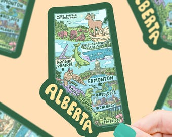 May include: A green sticker depicting a map of Alberta, Canada, with illustrations of landmarks and wildlife. The sticker includes the text "Alberta" in a curved design and highlights cities like Edmonton and Calgary.