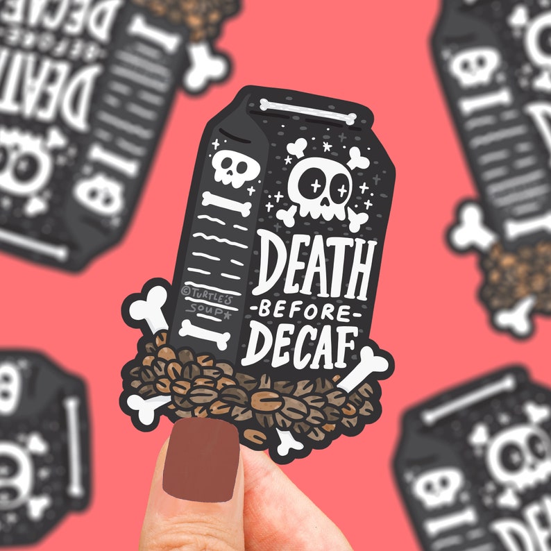 May include: A black and white sticker of a coffee carton with a skull and crossbones and the text "Death Before Decaf". The sticker is surrounded by coffee beans and bones.