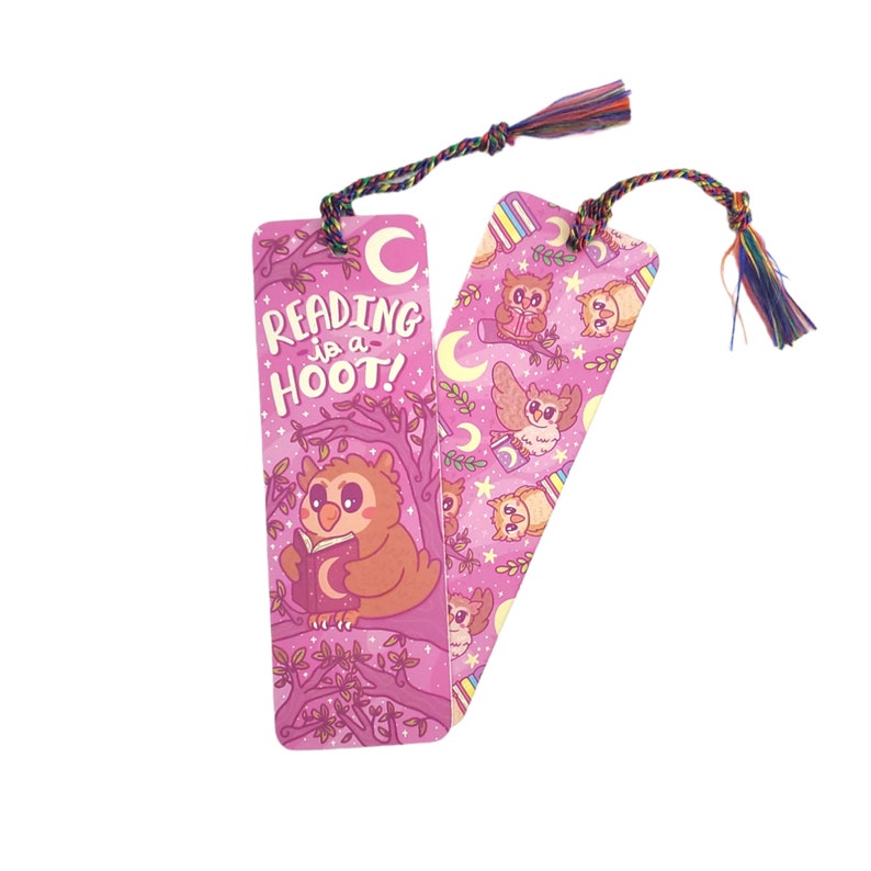 Pu&ograve; includere: Segnalibro rosa con un gufo carino che legge un libro. Il segnalibro ha il testo "Reading is a Hoot!" e un fiocco colorato.