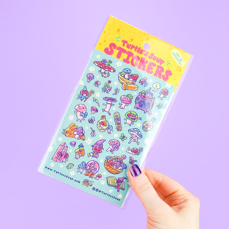 May include: A sheet of colorful stickers featuring whimsical mushroom and fantasy-themed illustrations. The stickers are packaged in a clear plastic sleeve with the text "Turtle's Soup Stickers" in pink and yellow. The background is a light blue with small white stars.