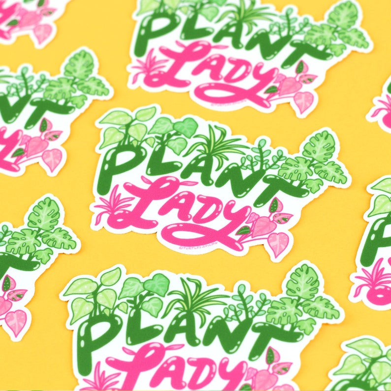 K&ouml;nnte beinhalten: Ein Set mit drei wei&szlig;en Aufklebern mit dem Text "Plant Lady" in gr&uuml;ner und rosa Schrift. Jeder Aufkleber zeigt verschiedene gr&uuml;ne und wei&szlig;e Pflanzenillustrationen.