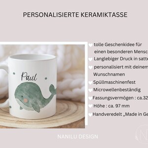 May include: White ceramic mug with a green whale illustration and the name "Paul" printed on it. The mug is personalized with a name and is dishwasher and microwave safe. It has a capacity of 325 ml and is 97 mm tall.
