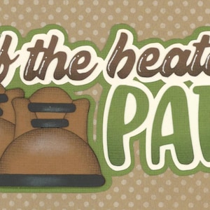 May include: A decorative card with the phrase "Off the beaten path" in brown and green lettering. Two brown boots are featured below the text. The background is tan with white polka dots.