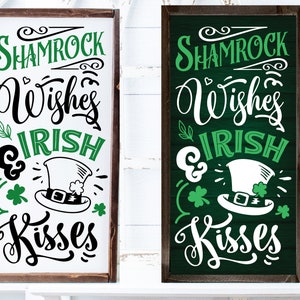 Pode incluir: Dois sinais de madeira com um trevo verde, um chapéu de duende e o texto "Shamrock Wishes & Irish Kisses". Um sinal tem um fundo branco com texto verde e o outro tem um fundo verde com texto branco.