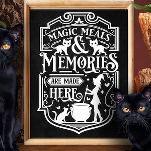 May include: A black chalkboard sign with white text that reads "Magic Meals & Memories Are Made Here". The sign is decorated with a witch, a cauldron, and cats. Two black cats are sitting on either side of the sign.