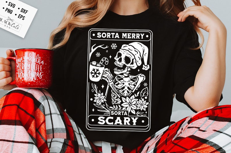 May include: A black t-shirt with a white graphic of a skeleton wearing a Santa hat and holding a mug of hot chocolate. The graphic is surrounded by a white border and the text "Sorta Merry" and "Sorta Scary" in white.