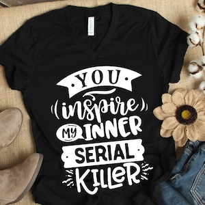 May include: Black v-neck t-shirt with white text that reads "You (inspire) my inner serial killer".