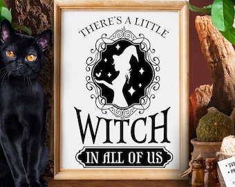 May include: A white sign with black text and a silhouette of a witch in a frame. The text reads "There's a little witch in all of us".