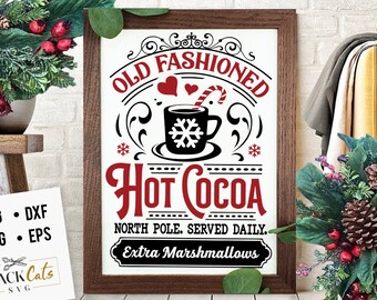 May include: A framed sign with a vintage design featuring a red mug of hot cocoa with a candy cane and the text "Old Fashioned Hot Cocoa North Pole. Served Daily. Extra Marshmallows".