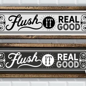 May include: Two wooden signs with the text "Flush It Real Good" in black and white lettering. The signs are framed in a dark wood frame. The top sign has a white background and the bottom sign has a black background.