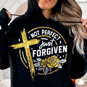 May include: Black hoodie with a gold glitter design that says "Not Perfect Just Forgiven" with a cross and flowers.