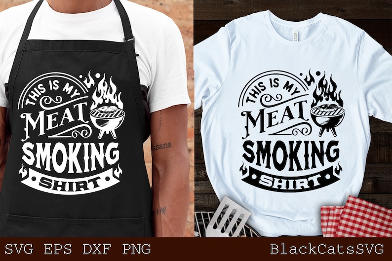 Pu&ograve; includere: Grembiule nero e maglietta bianca con la scritta "THIS IS MY MEAT SMOKING SHIRT" in un design circolare con una grafica di griglia. Il grembiule &egrave; indossato da una persona. La maglietta &egrave; su una superficie di legno.