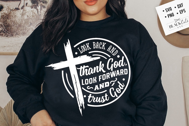 Może przedstawiać: Czarna bluza z białym krzyżem i napisem "Look back and thank God, look forward and trust God." Mała biała karta w prawym g&oacute;rnym rogu zawiera napisy "SVG, DXF, PNG, EPS" i "Black Cats SVG."