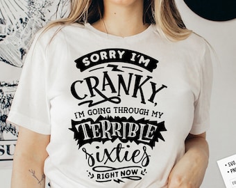 May include: White t-shirt with black text that reads "Sorry I'm Cranky, I'm going through my Terrible Sixties Right Now".