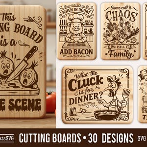 May include: A collection of wooden cutting boards with humorous kitchen-themed designs. One board features a knife, carrots, and onions with the text "This Cutting Board is a Crime Scene." Other boards have cartoon illustrations and text.
