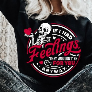 May include: Black sweatshirt with a graphic design featuring a skeleton holding a heart. The text reads "IF I HAD Feelings, THEY WOULDN'T BE FOR YOU ANYWAY." The design is in red and white.