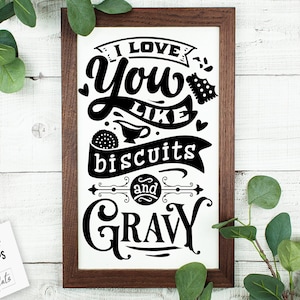 May include: A framed black and white sign with the text "I love you like biscuits and gravy".