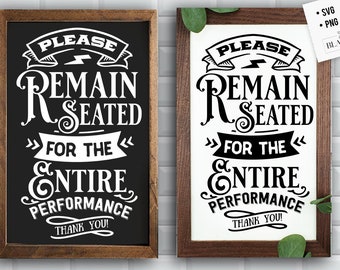 May include: Two black framed signs with white text that reads "Please Remain Seated for the Entire Performance Thank You!" The signs are on a white tiled wall.