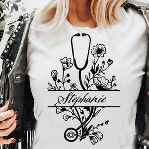 May include: Black and white graphic design featuring a stethoscope with floral accents and the name "Stephanie" written in a script font.