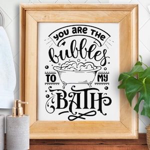 Puede incluir: Una impresión enmarcada en blanco con texto negro que dice "You are the bubbles to my bath." El texto está en una fuente decorativa e incluye un dibujo de una bañera con burbujas.