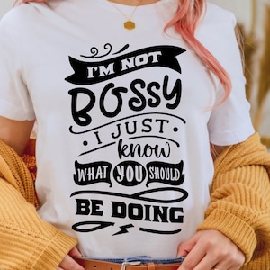 May include: White t-shirt with black text that reads "I'm not bossy, I just know what you should be doing".