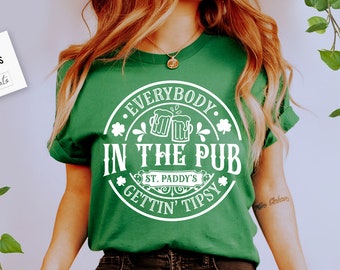 May include: Green t-shirt with a white circle design that says "Everybody in the Pub Gettin' Tipsy" with a shamrock and beer mugs inside the circle.