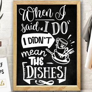 Puede incluir: Una pizarra negra con una inscripción blanca que dice "Cuando dije "SÍ, QUIERO" no quería decir LOS PLATOS". La inscripción está en una fuente manuscrita. Hay dibujos de platos y cubiertos en la pizarra.