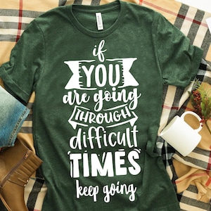Peut inclure: T-shirt vert avec un texte blanc qui dit "if you are going through difficult times keep going".