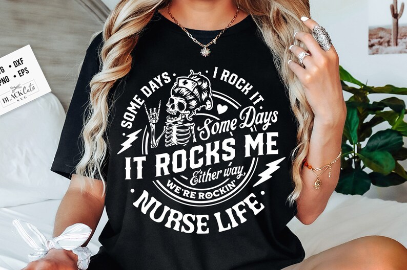 Peut inclure: T-shirt noir avec un motif blanc repr&eacute;sentant un squelette portant une coiffe d'infirmi&egrave;re, faisant un geste de rock and roll. Le texte dit "Some days I rock it, Some days it rocks me, Either way, we're rockin' Nurse Life."