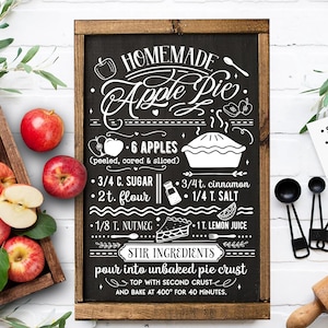 May include: A black chalkboard sign with white text and illustrations, featuring a recipe for homemade apple pie. The sign includes a list of ingredients, such as 6 apples, 3/4 cup sugar, 2 teaspoons flour, 3/4 teaspoon cinnamon, 1/4 teaspoon salt, 1/8 teaspoon nutmeg, and 1 tablespoon lemon juice. The sign also includes instructions to stir the ingredients, pour them into an unbaked pie crust, top with a second crust, and bake at 400 degrees Fahrenheit for 40 minutes.