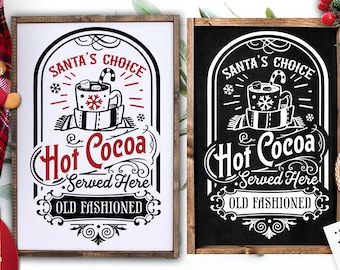 May include: Two black framed signs with white text and graphics. The signs advertise "Santa's Choice Hot Cocoa Served Here Old Fashioned". One sign has a white background and the other has a black background.