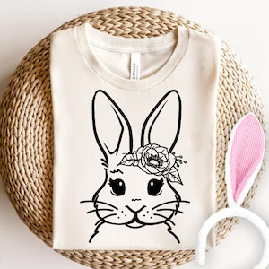 May include: A white t-shirt featuring a black and white illustration of a bunny wearing a flower crown. The bunny is looking directly at the viewer.