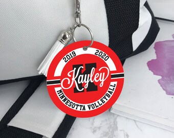 May include: Red, white, and black round keychain with the text "2019 Kayley 2020 Minnesota Volleyball" and a black letter "K" in the center.
