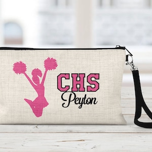 May include: A white canvas zippered pouch with a black zipper and a black strap. The pouch has a pink silhouette of a cheerleader with pom-poms and the text "CHS Peyton" in black and pink.