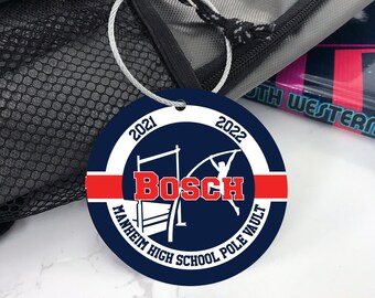 May include: A blue and white circle with the text "2021" and "2022" on either side of a white circle. The text "Bosch" is in the center of the circle in white letters. The text "Mannheim High School Pole Vault" is around the bottom of the circle. There is a red stripe across the top of the circle.
