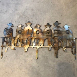Cowboy Welcome sign cowboys sitting on a fence metal welcome home sign