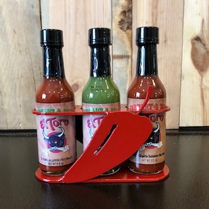 Hot sauce display caddy holds 3 bottles of hot sauce with chili peppers made out of steel & powdercoated